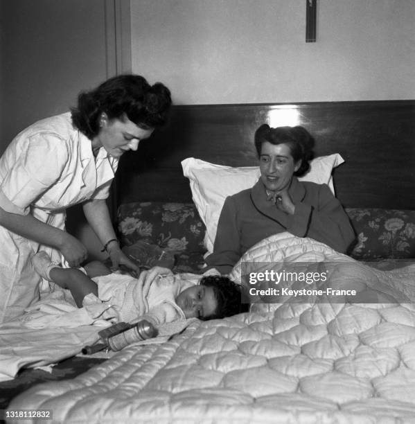 Gouvernante changeant la couche d'un bébé, en février 1949.