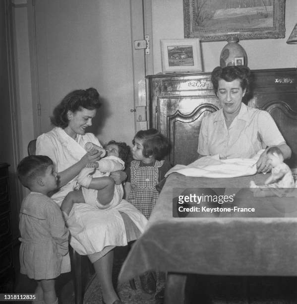 Gouvernante donnant le biberon à un bébé, en février 1949.