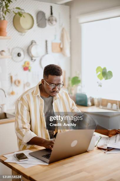 young man does online stock trades at home - different loans stock pictures, royalty-free photos & images