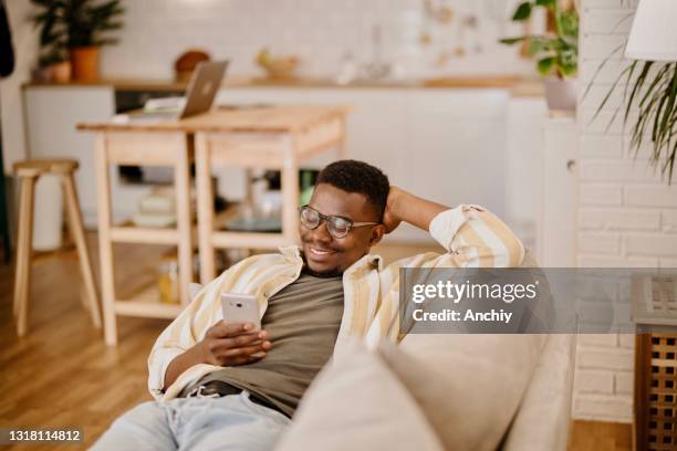 young man using online dating app while relaxing at home. - meme stock stock pictures, royalty-free photos & images