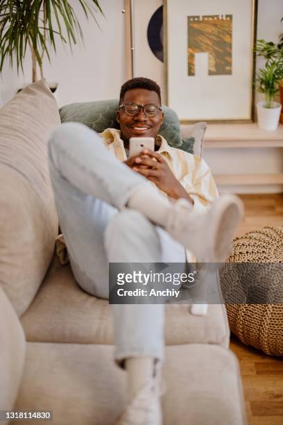 young man relaxing at home, watching funny videos and photos online. - meme text stock pictures, royalty-free photos & images