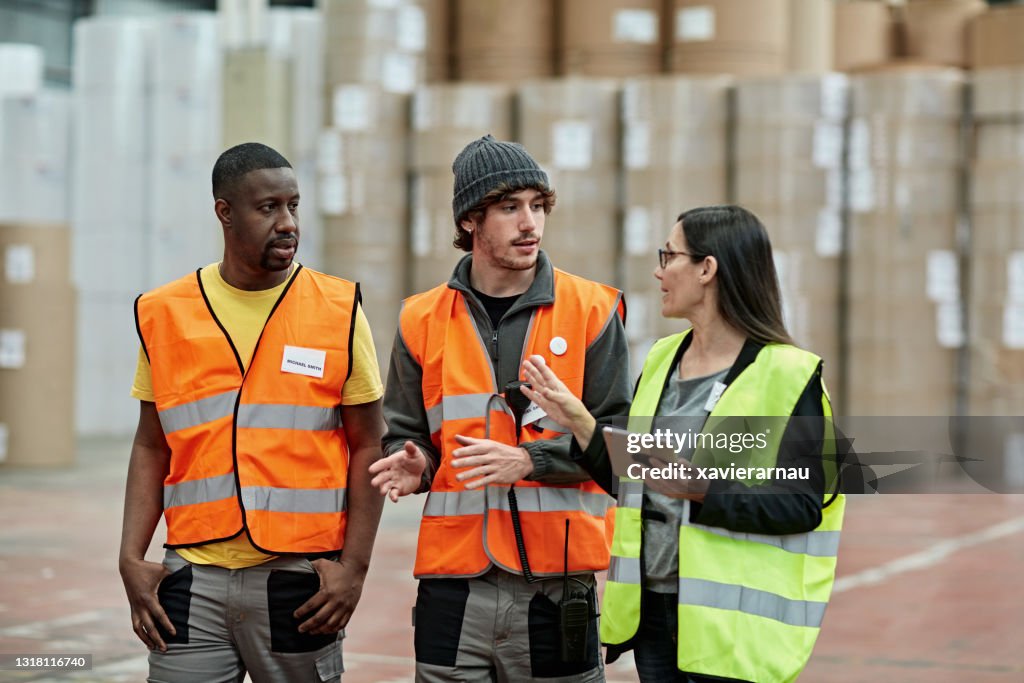 Female foreperson Making Plans with Warehousemen