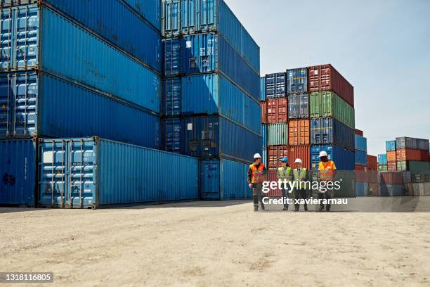 team logistico che cammina insieme nel porto interno - contenitore foto e immagini stock