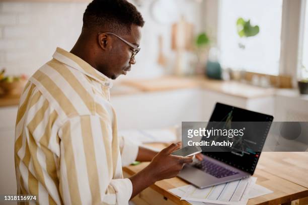 young man investing or trading in bitcoin or other cryptocurrencies - broker stock pictures, royalty-free photos & images