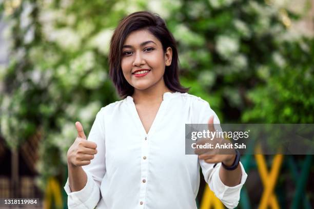 happy late teen girl of indian ethnicity showing thumbs up - indian college girls stock pictures, royalty-free photos & images