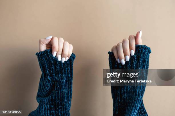 female hands with white manicure on a pink background. - lime photos et images de collection