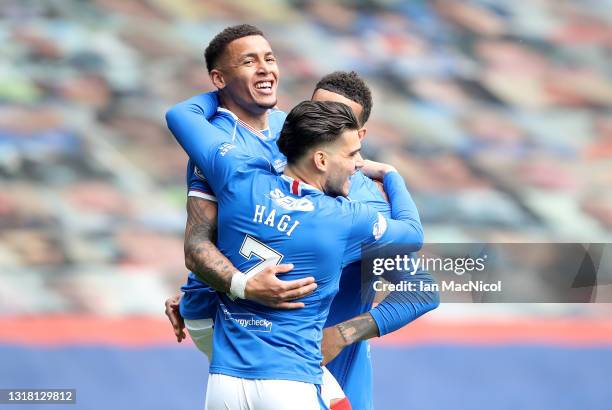 James Tavernier of Rangers celebrates their team's first goal with Ianis Hagi and Connor Goldson , an own goal scored by Joe Lewis of Aberdeen during...