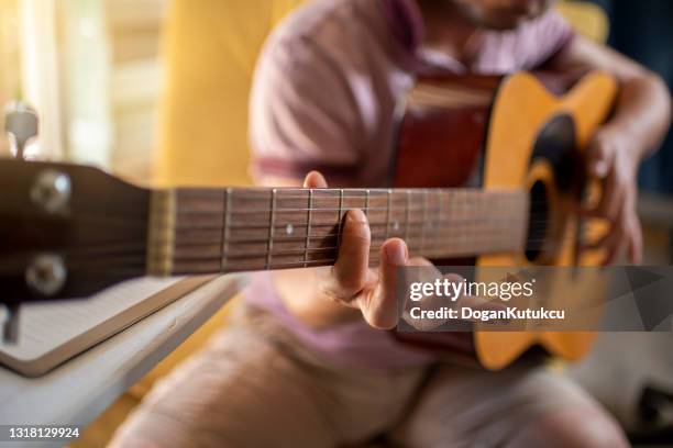 the young musician composes with the acoustic guitar. - acoustic guitarist stock pictures, royalty-free photos & images