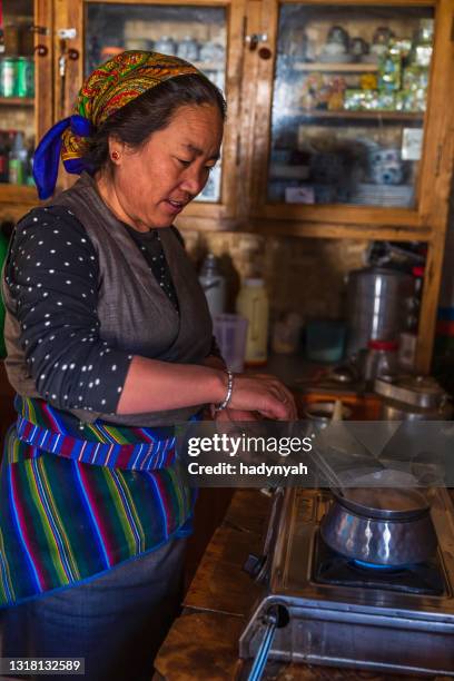 tibetan woman preparing meal, upper mustang, nepal - nepal food stock pictures, royalty-free photos & images