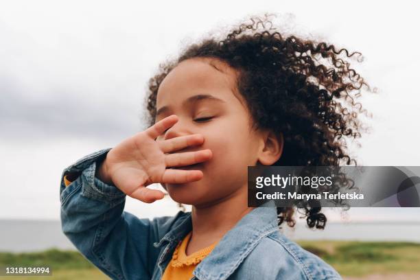 portrait of a smiling dark curly-haired girl. - air child play stock-fotos und bilder