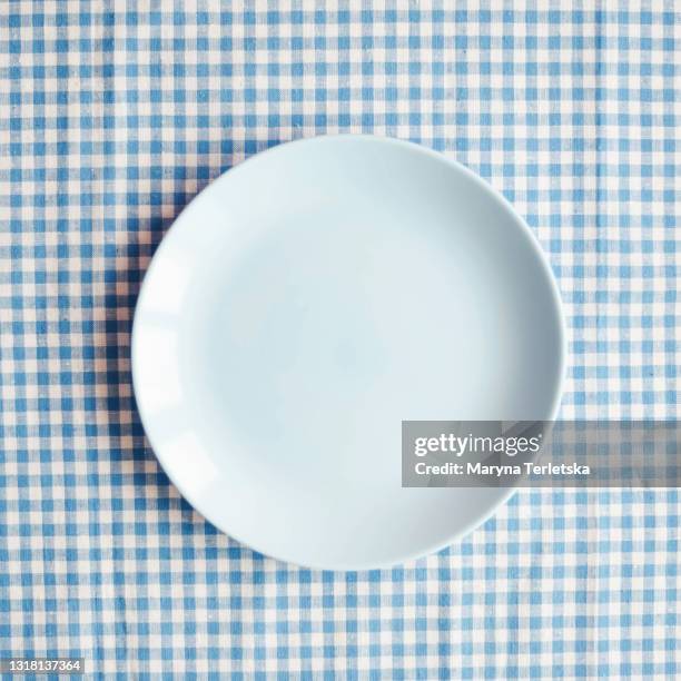 blue plate on a checkered blue-white fabric. t - breakfast top view stock pictures, royalty-free photos & images