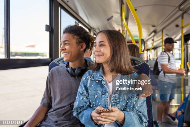 teenager-paar schaut durch fenster in bus - öffentliches verkehrsmittel stock-fotos und bilder