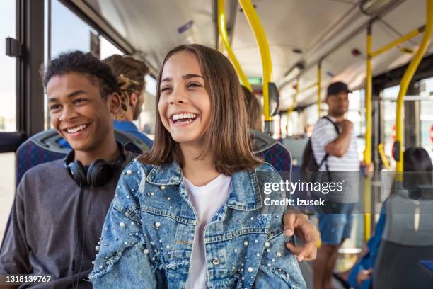 smiling teenage couple traveling in bus - casal adolescente imagens e fotografias de stock