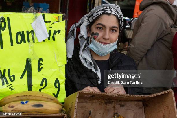 Woman wears a traditional Palestinian scarf with the country"u2019s flag painted on her cheek, during a demonstration in support of Palestine, which...