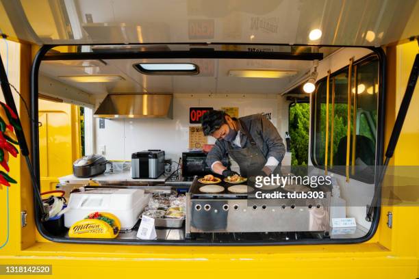 rijpe mens die taco's in zijn voedselvrachtwagen maakt - foodtruck stockfoto's en -beelden