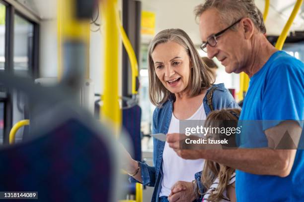 grandparents commuting with granddaughter in bus - fare stock pictures, royalty-free photos & images