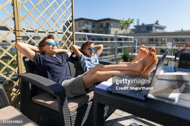 little boys attending to online class from their apartment terrace - lazy poland stock pictures, royalty-free photos & images