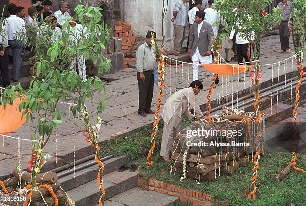 Man arranges sandlewood and marigold blossoms on a funeral pyre for a member of the Nepalese royal family June 2, 2001 in Kathmandu, Nepal before a...