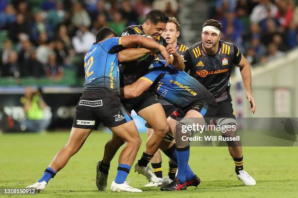 Anton Lienert-Brown of the Chiefs is tackled by Henry Taefu and Jeremy Thrush of the Force during the round one Super Rugby Trans-Tasman match...