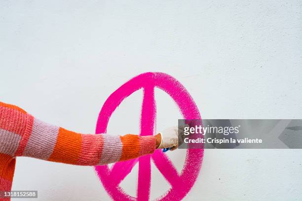 hand painting pink hippie symbol painted on a white wall - love graffiti stock pictures, royalty-free photos & images