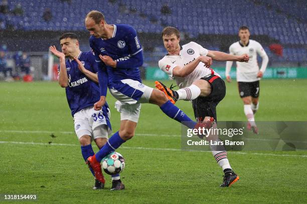 Martin Hinteregger of Eintracht Frankfurt takes a shot past Blendi Idrizi and Jonas Michelbrink of FC Schalke 04 during the Bundesliga match between...