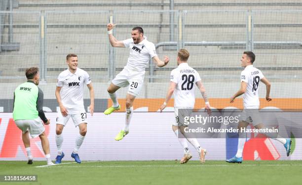 Daniel Caligiuri of FC Augsburg celebrates with Alfred Finnbogason and team mates after scoring their side's second goal from the penalty spot during...