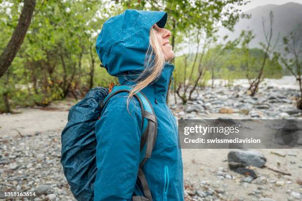 wanderer weiblich unter sintflutartigen regen, trägt sie wasserdichte kleidung - raincoat stock-fotos und bilder