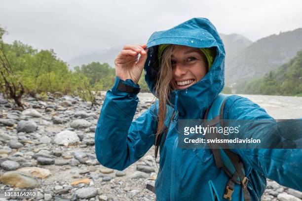 wandelaar vrouw onder de regen nemen een selfie - selfie woman stockfoto's en -beelden
