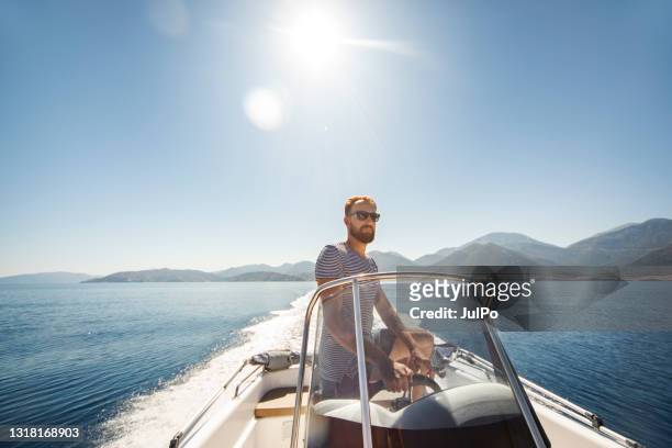 young man yachting alone - recreational boat stock pictures, royalty-free photos & images