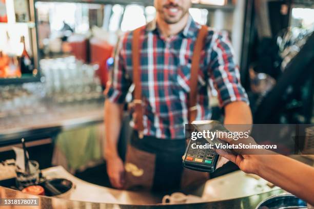 vrouw bij koffie die contactloos met slimme telefoon betaalt. - dichterbij komen stockfoto's en -beelden