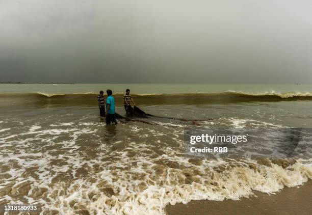 fisheman at sinquerim beach - sinquerim beach stock pictures, royalty-free photos & images
