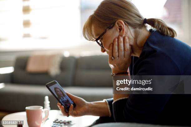 senior woman watching a medical video blog - telemedicine stock pictures, royalty-free photos & images