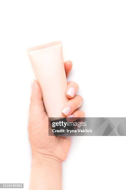 the bottle pink color cosmetic cream lotion in woman hand in milk bath. - handkräm bildbanksfoton och bilder