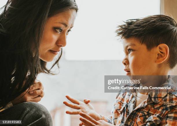 a little boy uses sign language to talk to a woman - affectionate fotografías e imágenes de stock