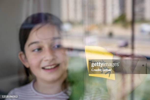 young girl hangs a message saying "thank you" on the window - thank you card stock pictures, royalty-free photos & images