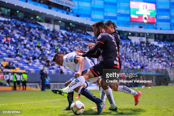 Daniel Álvarez of Puebla struggles for the ball against Pablo González and Víctor Malcorra of Atlas during the quarterfinals second leg match between...