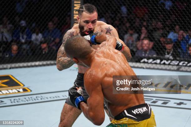 Edson Barboza of Brazil punches Shane Burgos in their featherweight bout during the UFC 262 event at Toyota Center on May 15, 2021 in Houston, Texas.