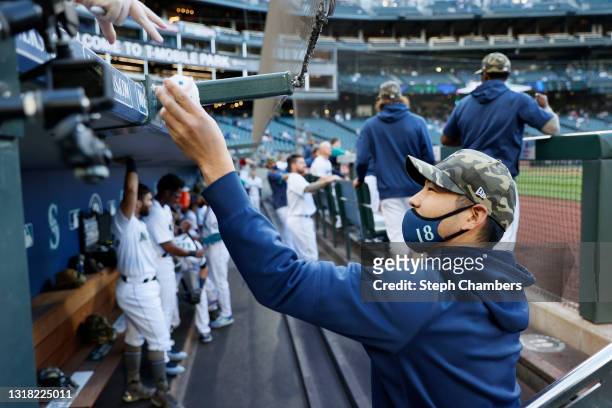 Yusei Kikuchi of the Seattle Mariners signs an autograph for a fan before the game against the Cleveland Indians at T-Mobile Park on May 15, 2021 in...