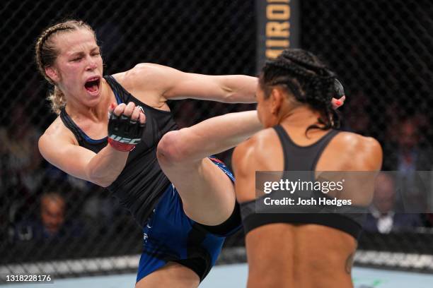 Katlyn Chookagian kicks Viviane Araujo of Brazil in their women's flyweight bout during the UFC 262 event at Toyota Center on May 15, 2021 in...