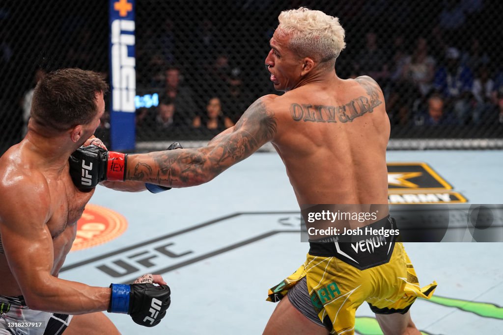 Charles Oliveira of Brazil punches Michael Chandler in their UFC