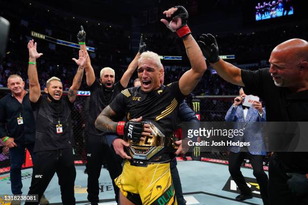 Charles Oliveira of Brazil reacts as UFC President Dana White places the UFC lightweight championship belt around his waist after defeating Michael...