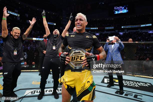 Charles Oliveira of Brazil reacts as UFC President Dana White places the UFC lightweight championship belt around his waist after defeating Michael...