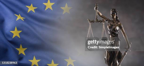 justice is blind statue symbolizing law and legal system with european union flag in the background. - courthouse background stock pictures, royalty-free photos & images