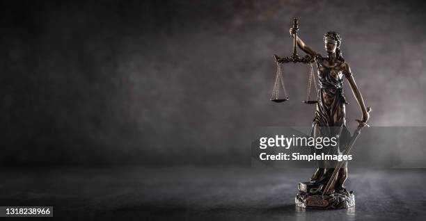 blind justice symbol on a metallic statue on a dark background. - justice concept stock-fotos und bilder