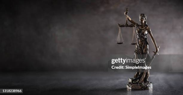 blind justice symbol on a metallic statue on a dark background. - legal system foto e immagini stock