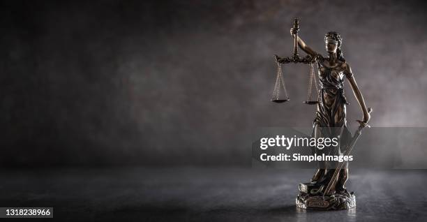 blind justice symbol on a metallic statue on a dark background. - lady justice stock pictures, royalty-free photos & images