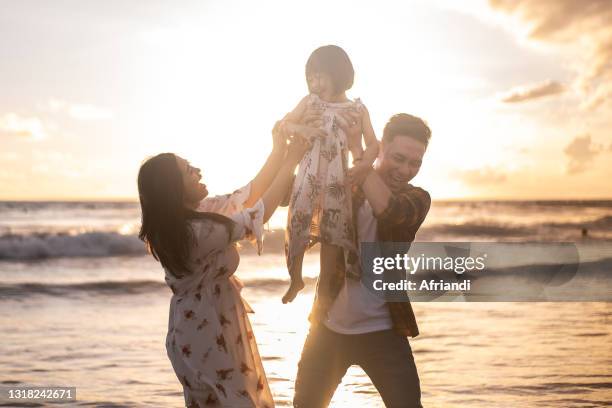 happy family enjoying sunset at the beach - kids fun indonesia stock pictures, royalty-free photos & images