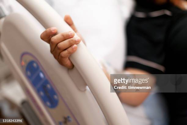 pregnant woman holding side of hospital bed in painful contractions before labor - railing stock pictures, royalty-free photos & images