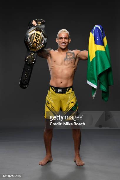 Charles Oliveira of Brazil poses for a post fight portrait with the UFC lightweight championship belt backstage during the UFC 262 event at Toyota...