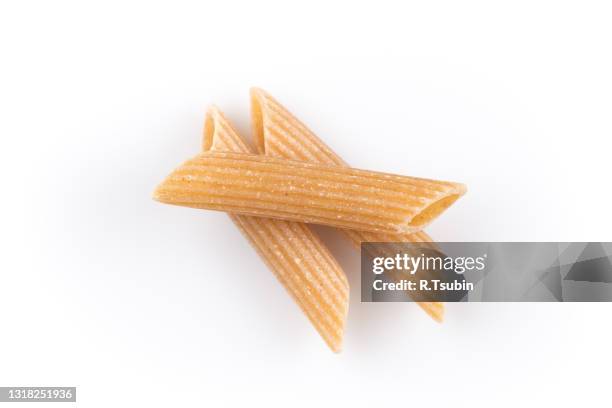 wholemeal pasta penne as close-up shot isolated on white background - whole wheat penne pasta stock pictures, royalty-free photos & images